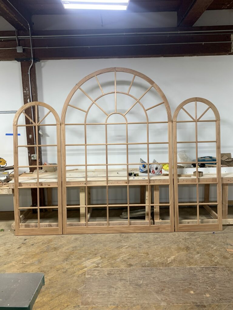 A Wooden Archway in a Workshop, With Tools and Workbenches in the Background.